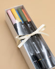 Boxed set of 12 Tombow dual brush pens in pink, yellow, blue and green, tied with a cream ribbon.