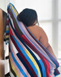 Person wrapped in a colorful terry cloth stretchy striped towel.