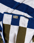 Close-up of a striped stretchy bath towel with the brand logo, Typical. 
