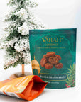 Varah Gourmet Masala Cranberries pouch in teal beside a snowy mini tree