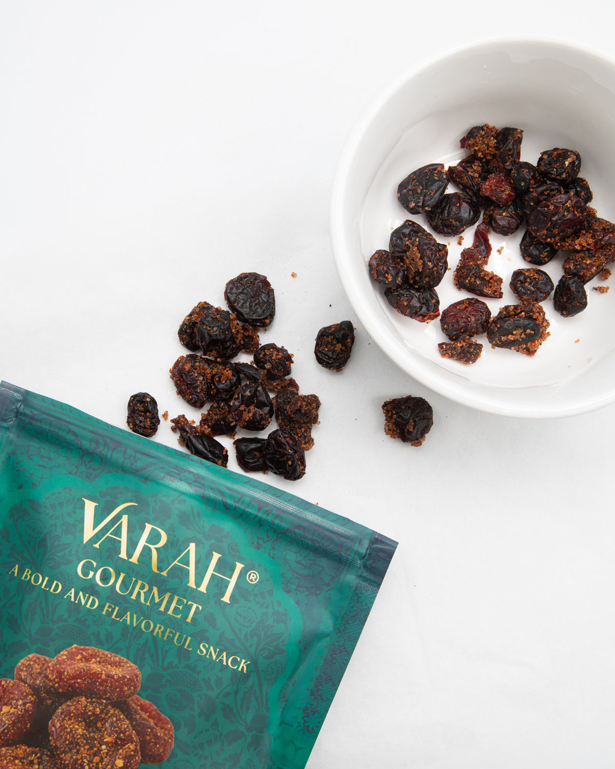 Masala spiced dried cranberries in a white bowl next to the Varah pouch