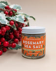 Jar of Wood Stove Kitchen Rosemary Sea Salt beside holly and red berries