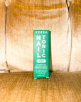 Zizia Nail Tonic box standing on a velvety gold armchair