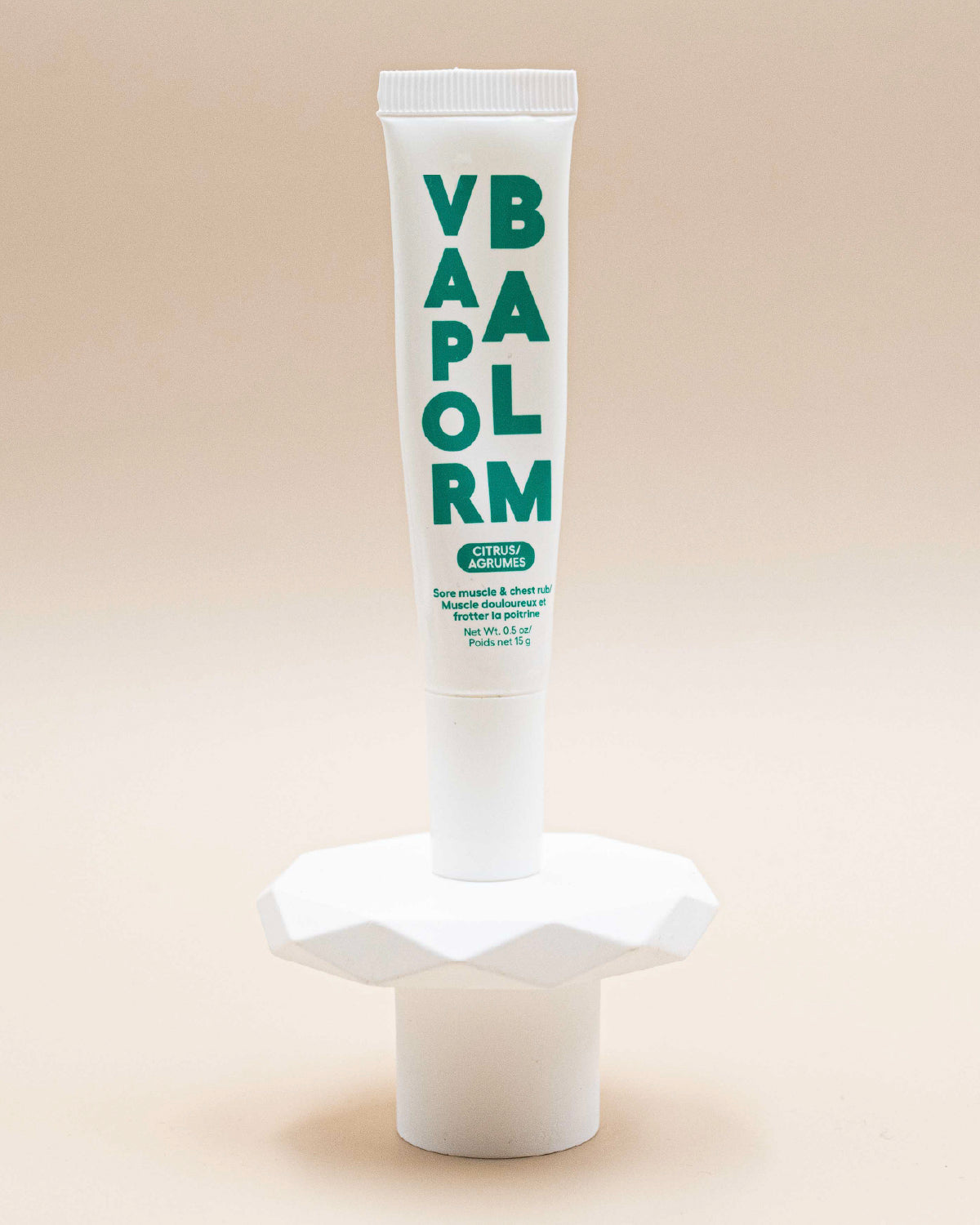 Zizia Vapor Balm tube in white with green lettering, standing on its cap